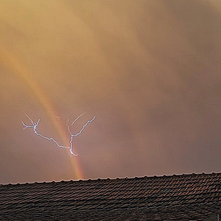 lucky observation of lightning over rainbow